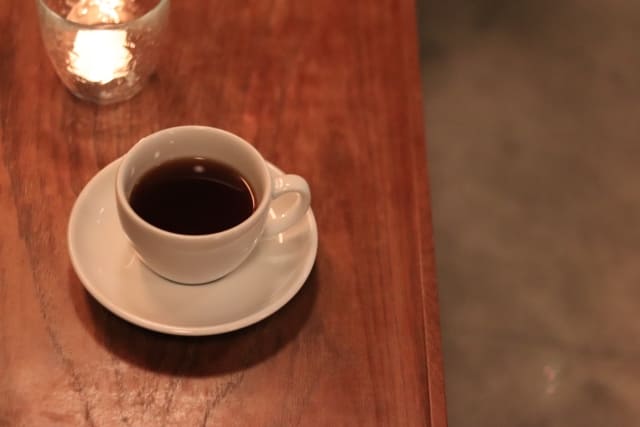 木製テーブルの上に置かれたコーヒーカップ